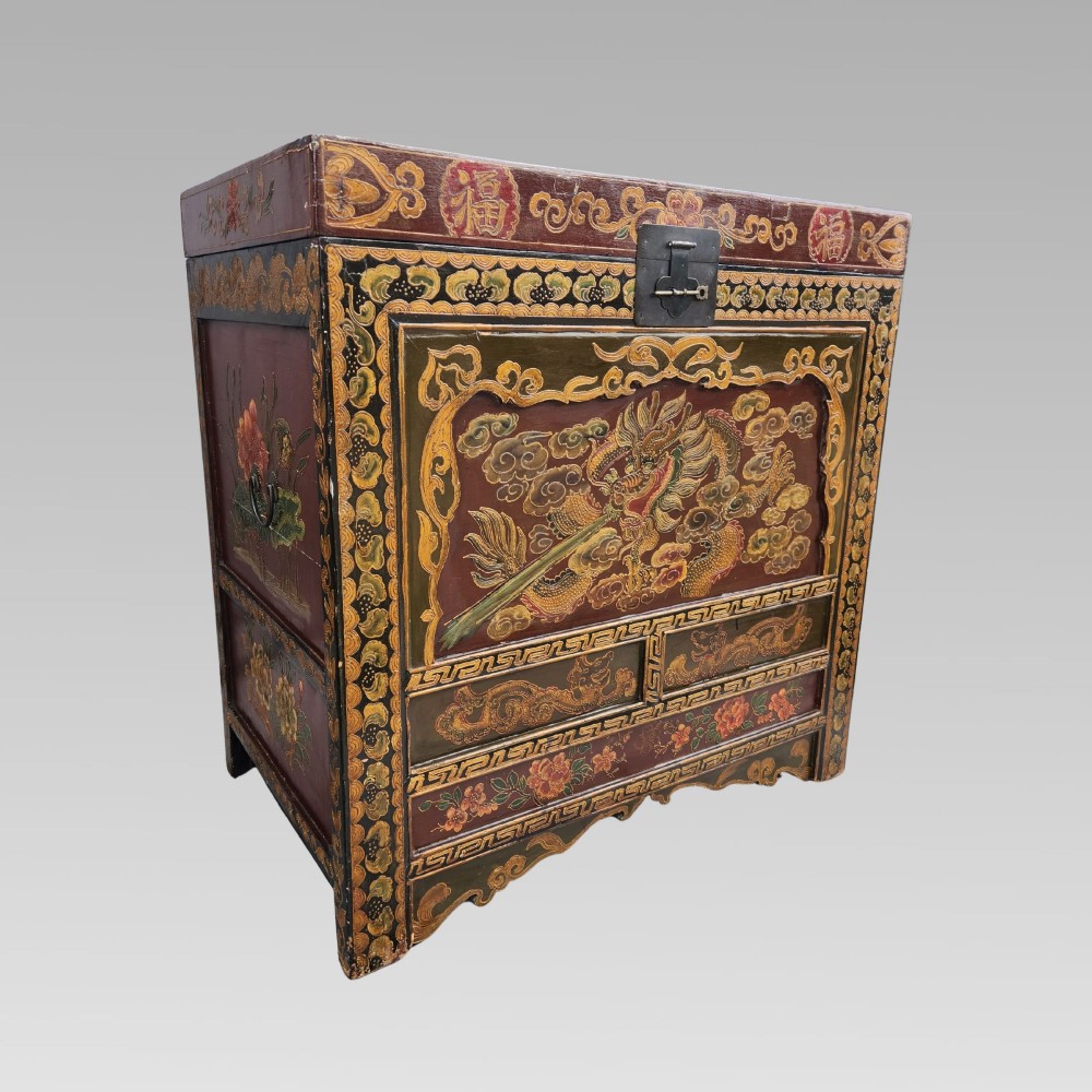 A large antique Chinese wooden storage chest decorated with hand-painted polychrome dragon motifs, floral borders, and brass hardware.