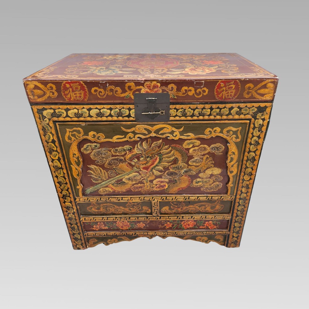 A large antique Chinese wooden storage chest decorated with hand-painted polychrome dragon motifs, floral borders, and brass hardware. View II