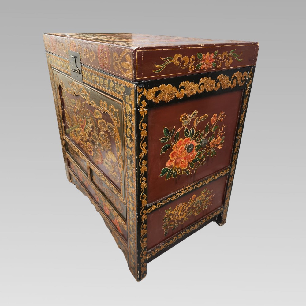 A large antique Chinese wooden storage chest decorated with hand-painted polychrome dragon motifs, floral borders, and brass hardware. View V