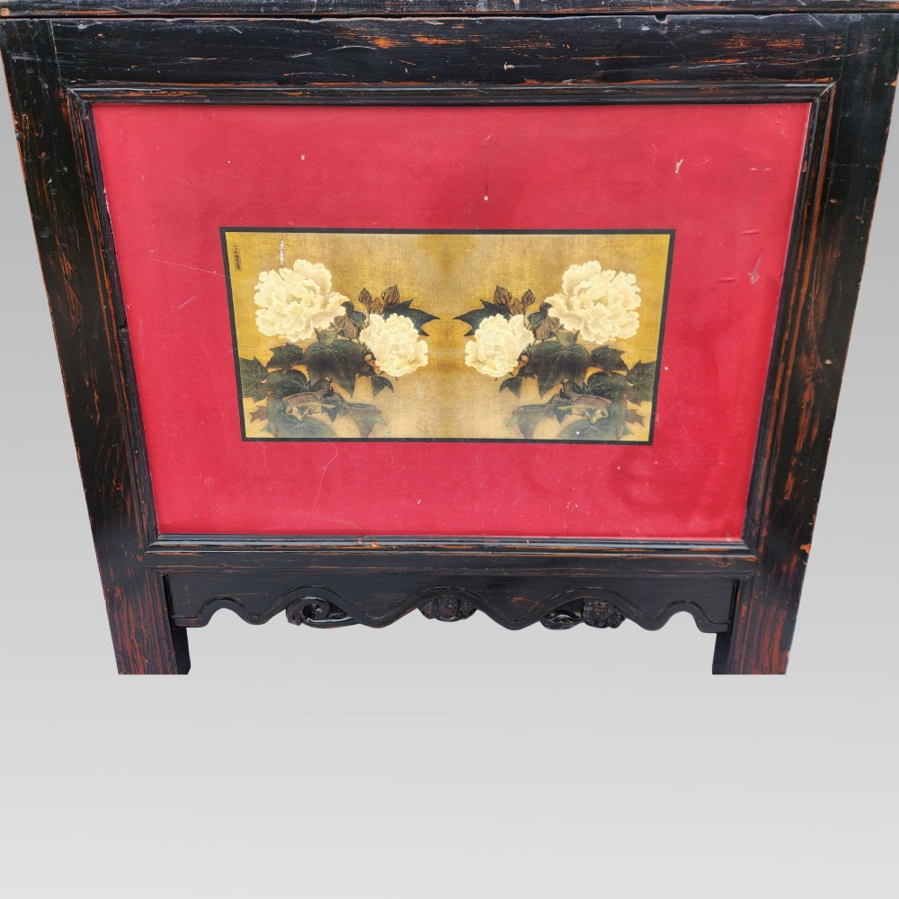 A dark lacquered wooden storage chest featuring a framed red panel with a hand-painted floral image of white peonies on a gold background. View IV