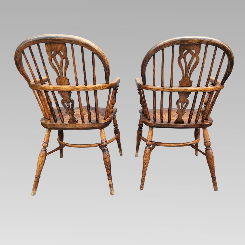 A pair of antique wooden Windsor armchairs featuring shaped elm seats, spindle backs with pierced central splats, and curved crinoline stretchers. View III