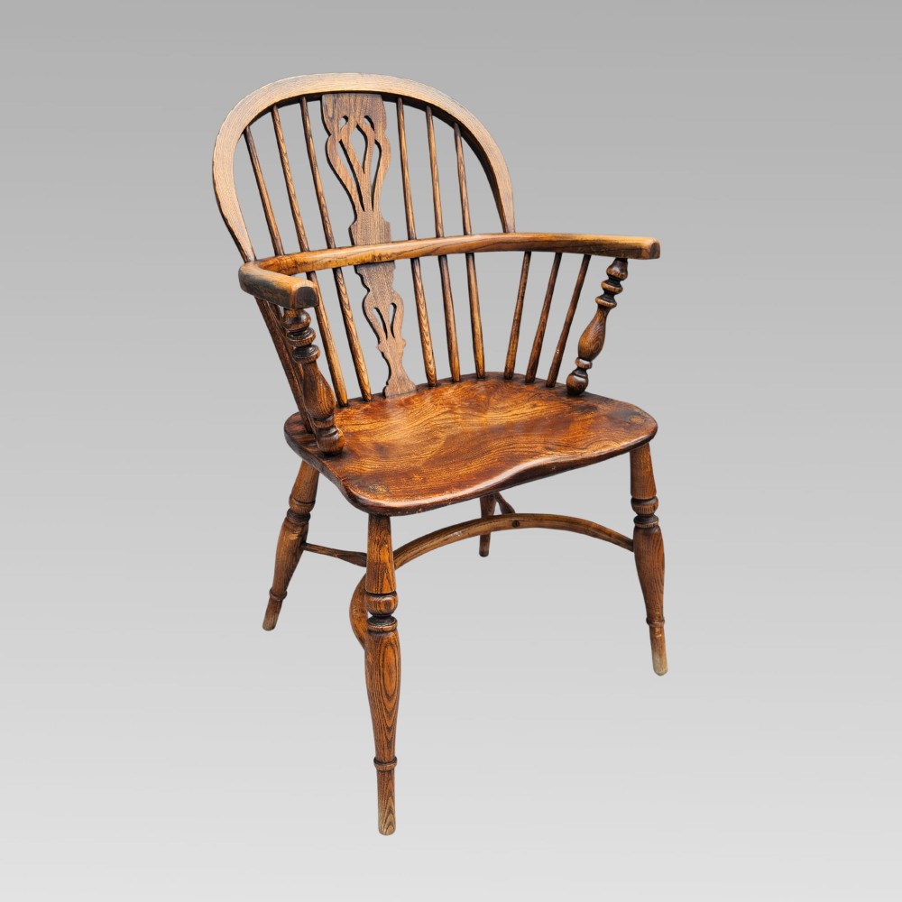 A pair of antique wooden Windsor armchairs featuring shaped elm seats, spindle backs with pierced central splats, and curved crinoline stretchers. View IV
