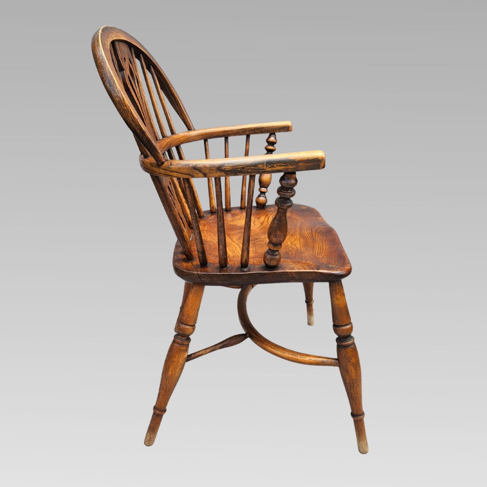 A pair of antique wooden Windsor armchairs featuring shaped elm seats, spindle backs with pierced central splats, and curved crinoline stretchers. View VII