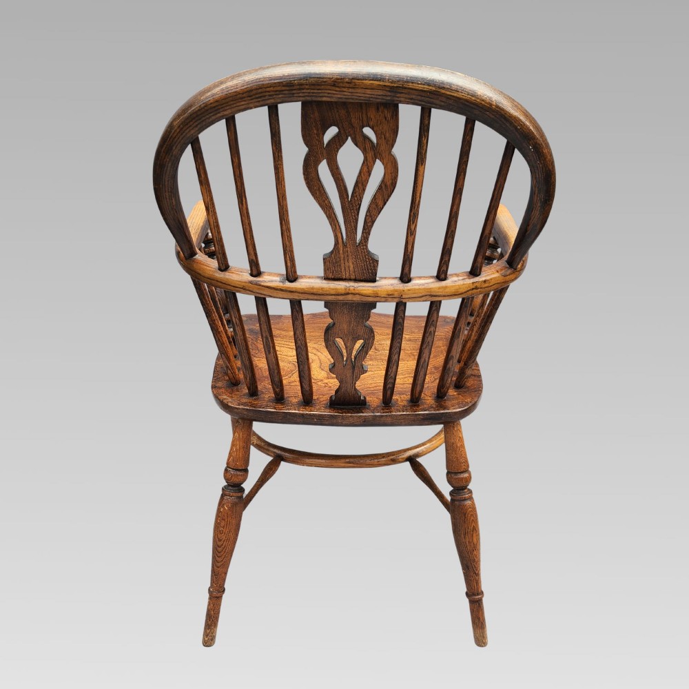 A pair of antique wooden Windsor armchairs featuring shaped elm seats, spindle backs with pierced central splats, and curved crinoline stretchers. View VIII