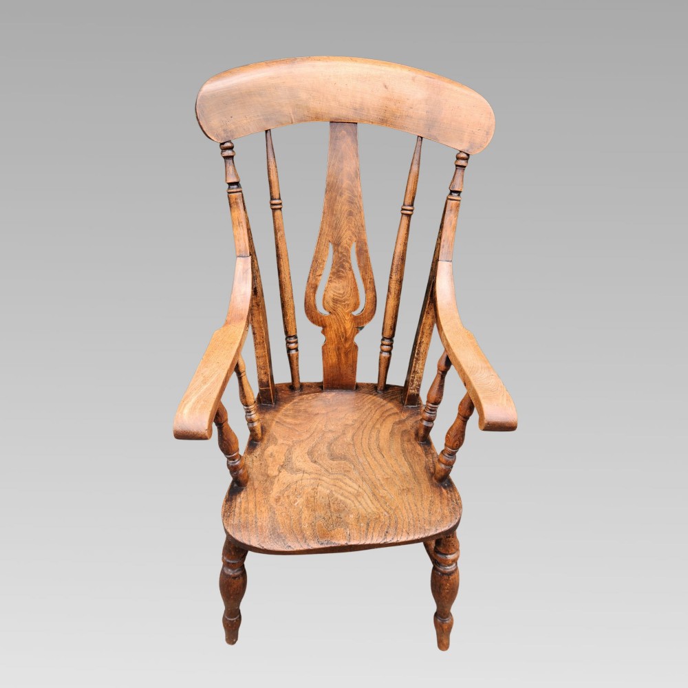 Victorian elm Windsor armchair featuring a central lyre-shaped splat, turned spindles, a curved crest rail, contoured solid seat, and turned wooden legs with stretchers. View II