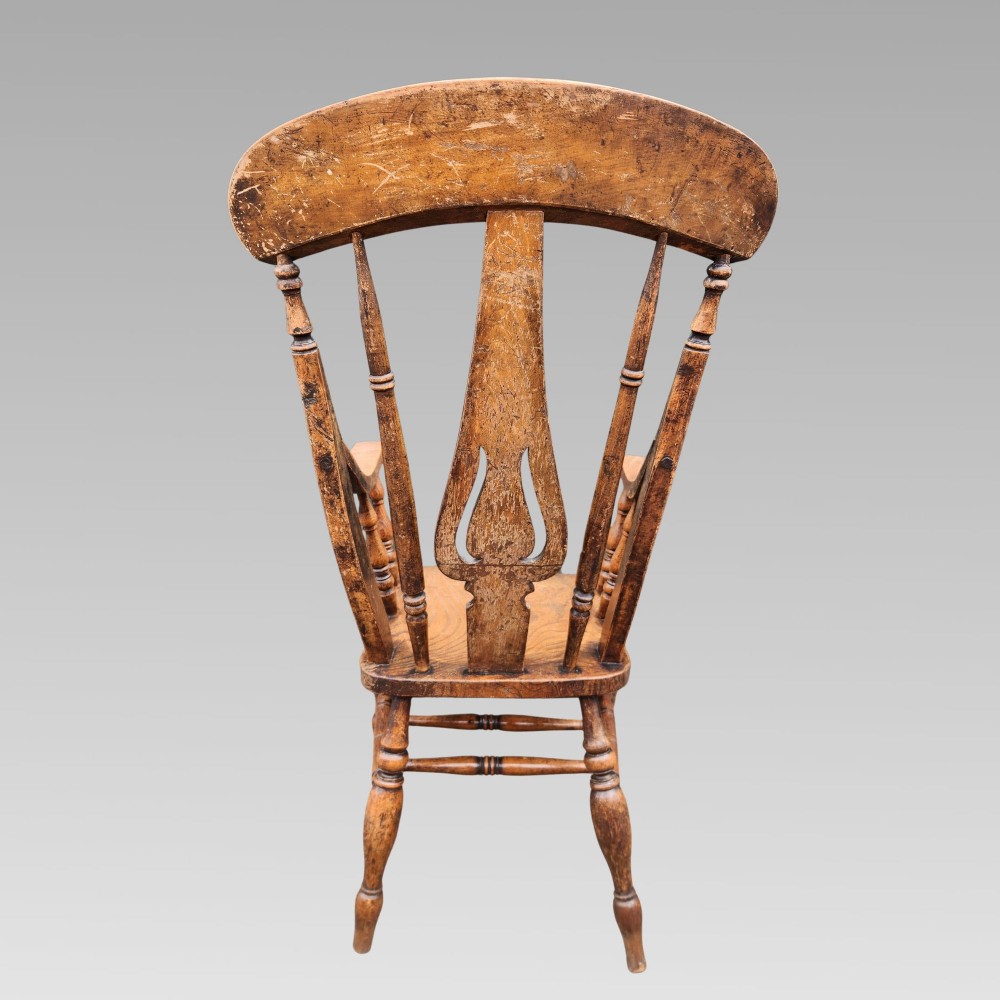 Victorian elm Windsor armchair featuring a central lyre-shaped splat, turned spindles, a curved crest rail, contoured solid seat, and turned wooden legs with stretchers. View V