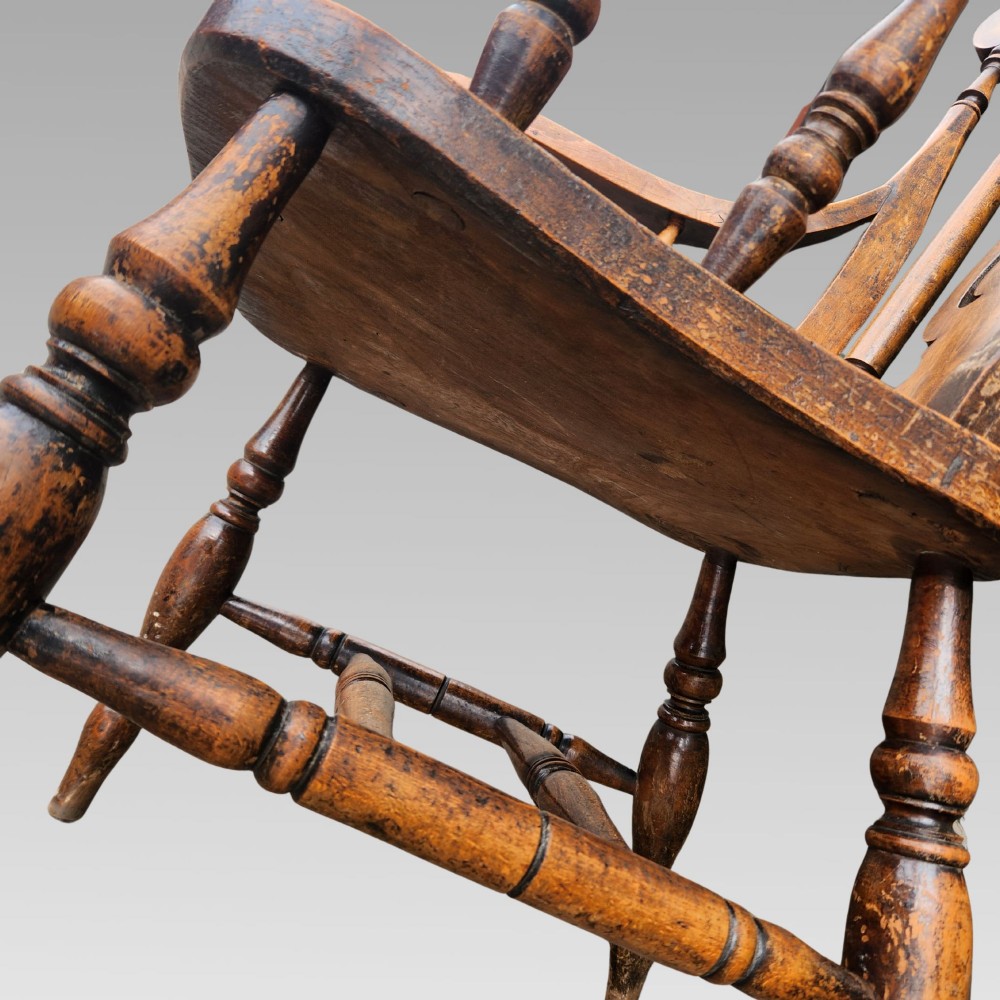 Victorian elm Windsor armchair featuring a central lyre-shaped splat, turned spindles, a curved crest rail, contoured solid seat, and turned wooden legs with stretchers. View VI