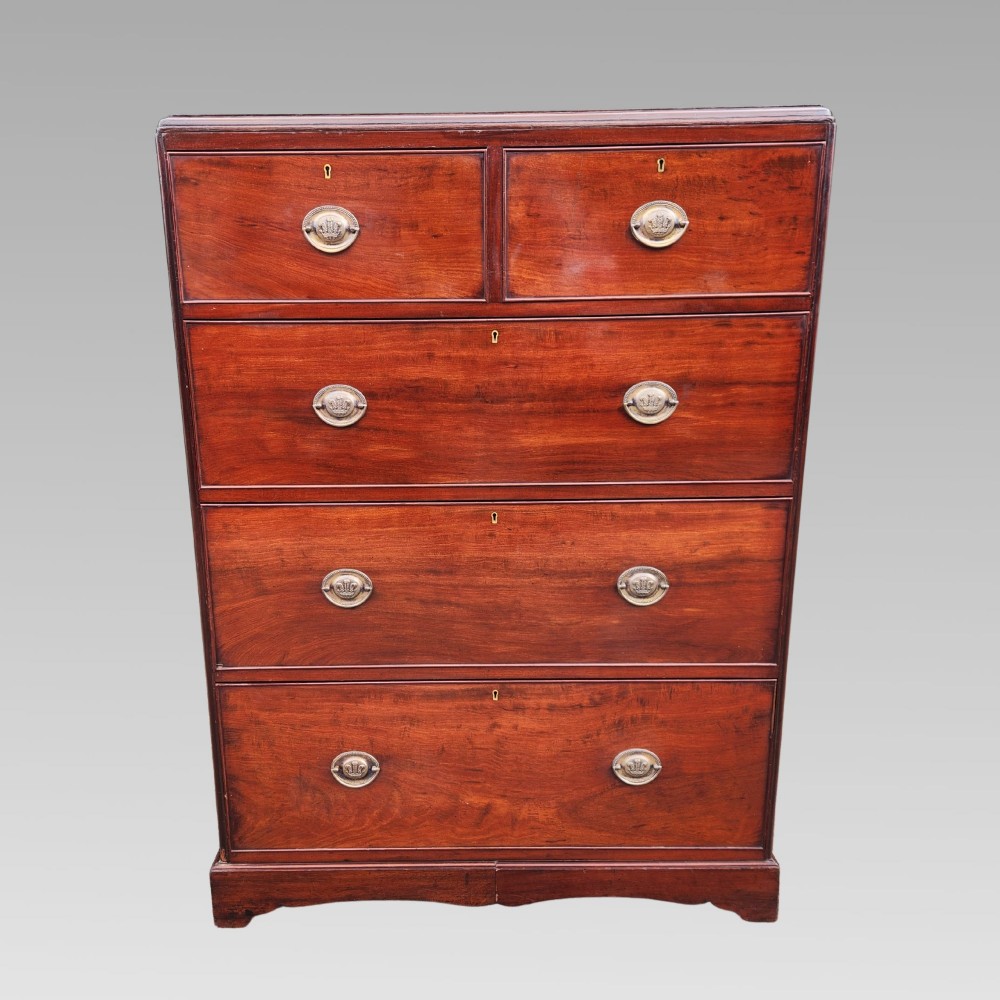A Victorian flame mahogany chest of drawers featuring two short over three long drawers with oval brass handles. View II