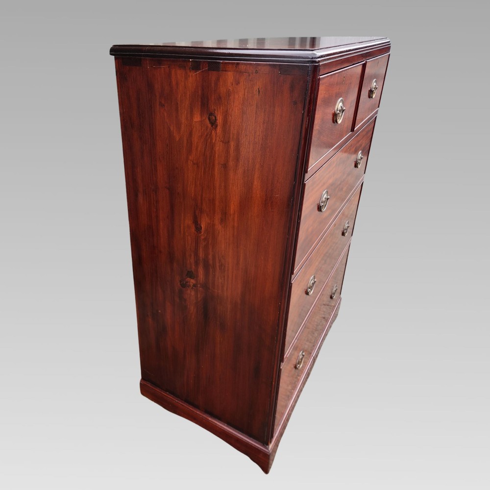 A Victorian flame mahogany chest of drawers featuring two short over three long drawers with oval brass handles. View V