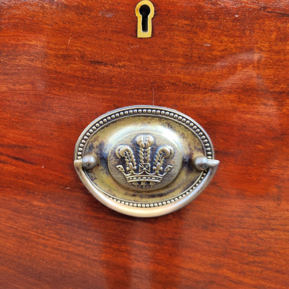 A Victorian flame mahogany chest of drawers featuring two short over three long drawers with oval brass handles. View VIII
