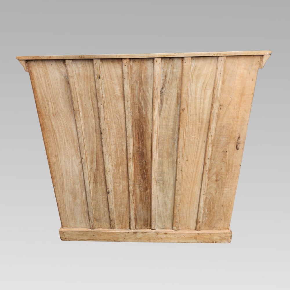 A light natural teak two-door storage cupboard featuring heavy iron straps, studs, and ring handles. View VI
