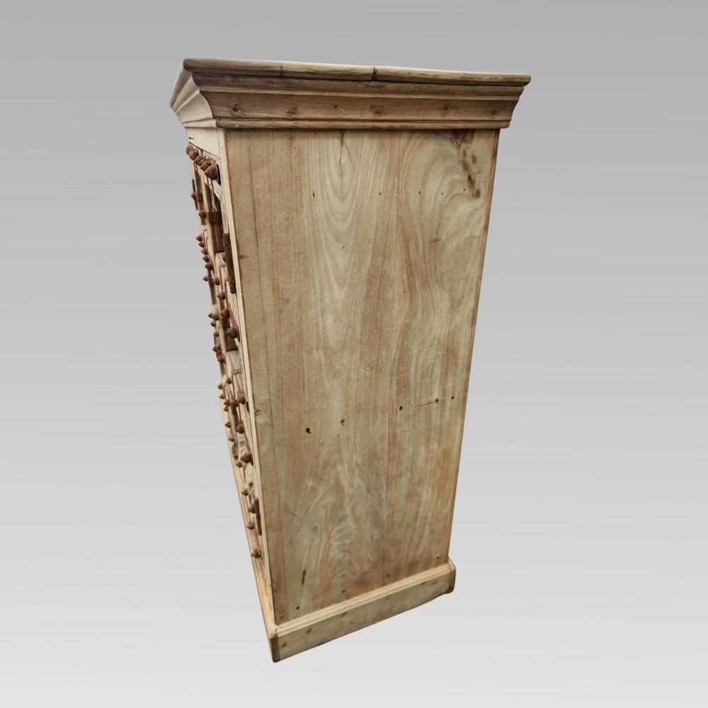 A light natural teak two-door storage cupboard featuring heavy iron straps, studs, and ring handles. View VIII