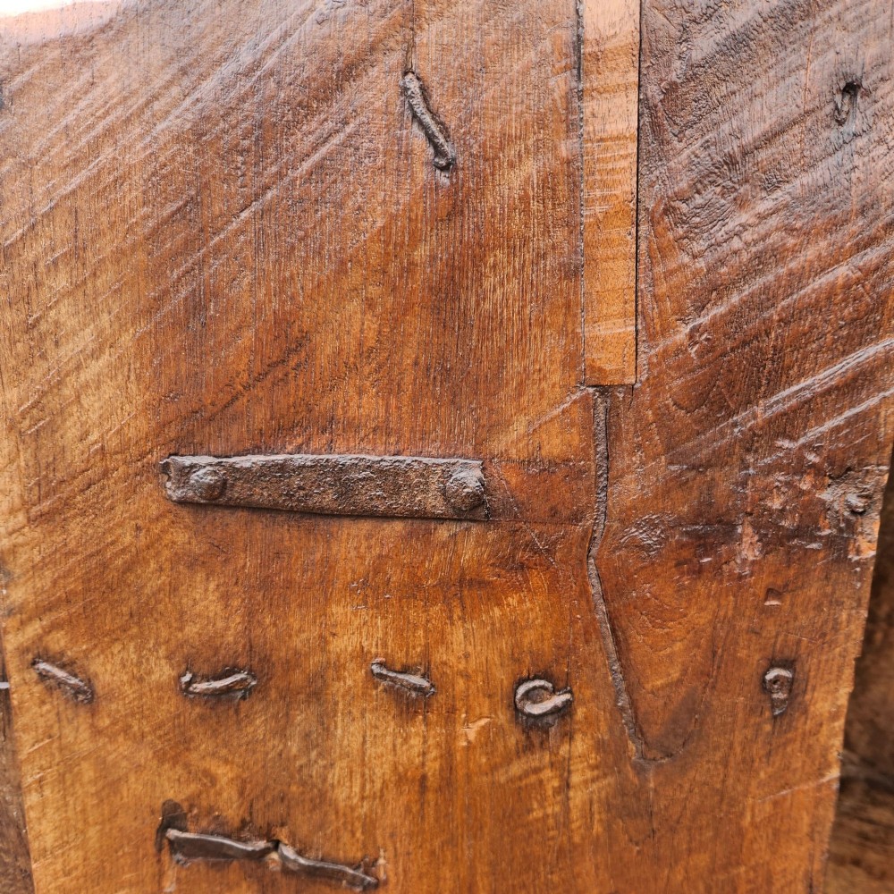 A tall antique Indian cupboard constructed from warm brown reclaimed teak wood with carved frame borders, panelled doors, and rustic iron ring handles. View VIII