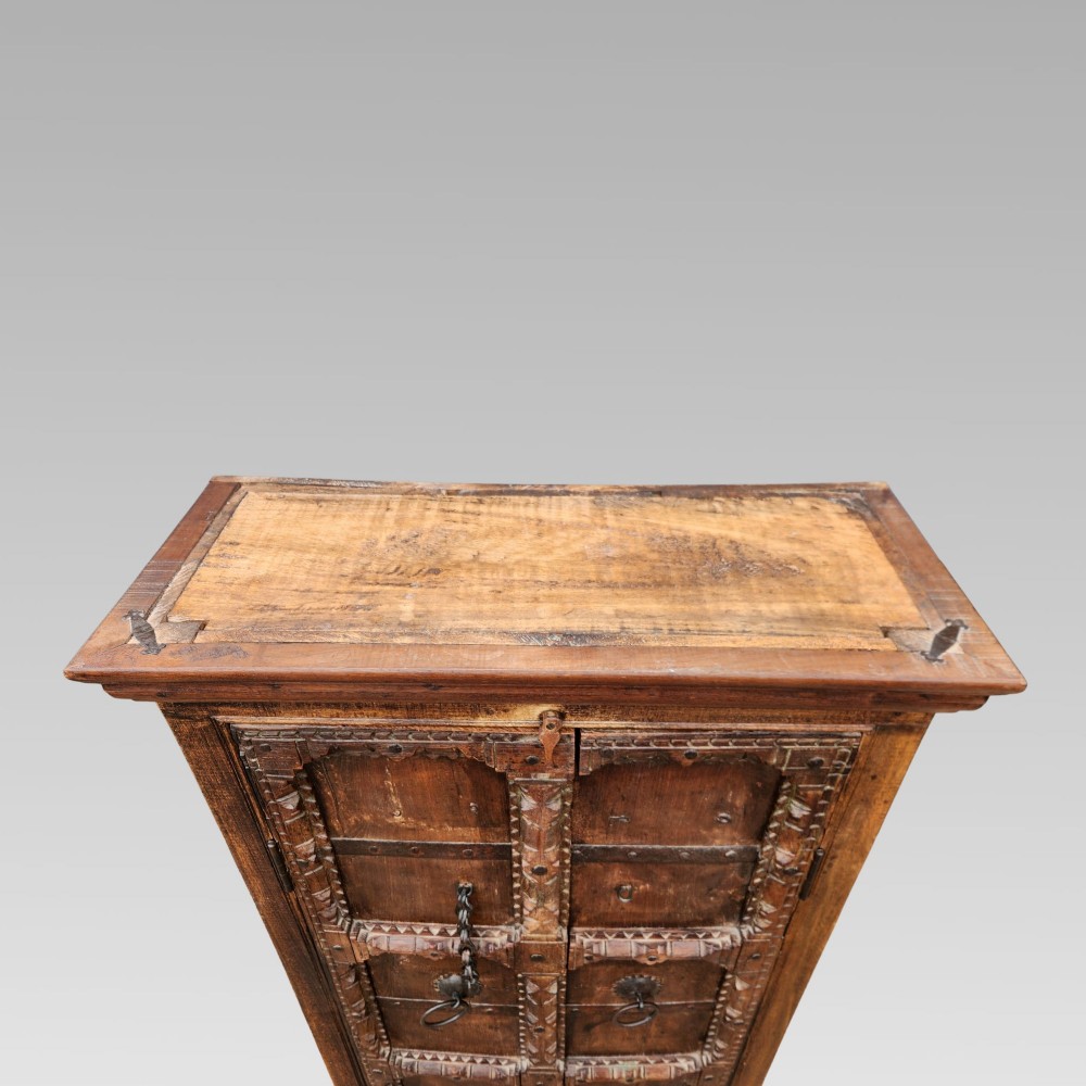 A tall antique Indian cupboard constructed from warm brown reclaimed teak wood with carved frame borders, panelled doors, and rustic iron ring handles. View IX