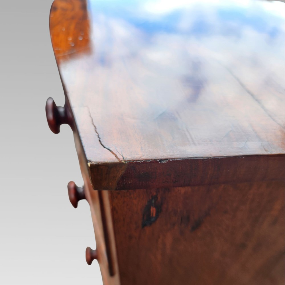 A Victorian mahogany bow-front chest of drawers featuring two short drawers over three long drawers with dark turned handles and turned feet. View XIII