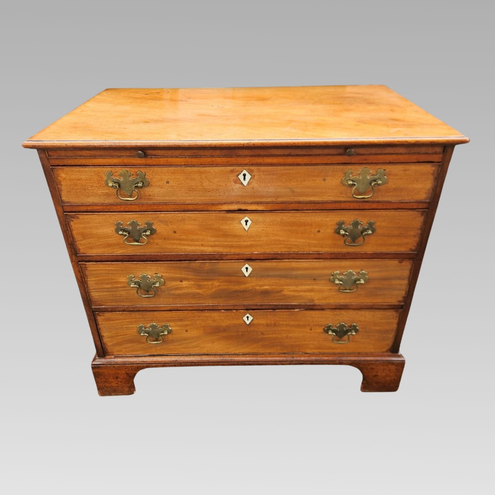 A Georgian mahogany chest of drawers featuring four graduated drawers with brass batwing handles, keyhole escutcheons, a brushing slide, and bracket feet. View II