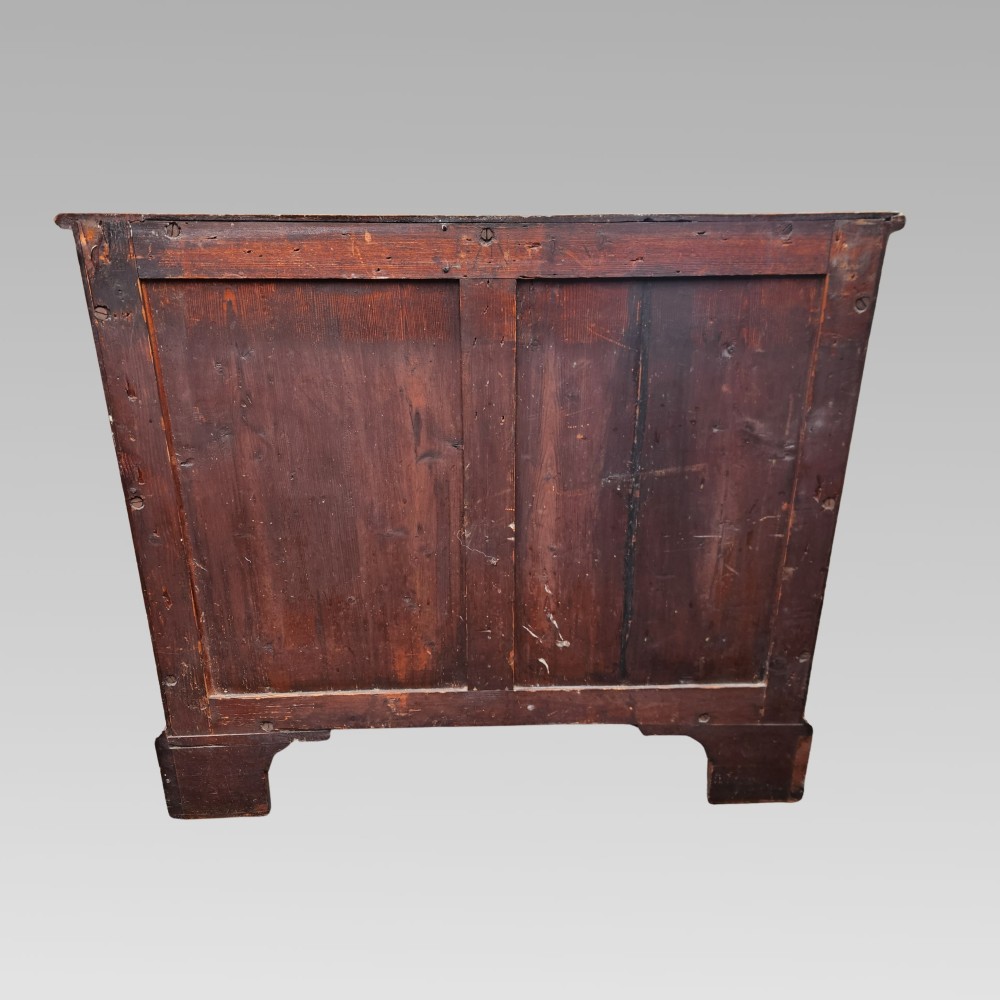A Georgian mahogany chest of drawers featuring four graduated drawers with brass batwing handles, keyhole escutcheons, a brushing slide, and bracket feet. View IX