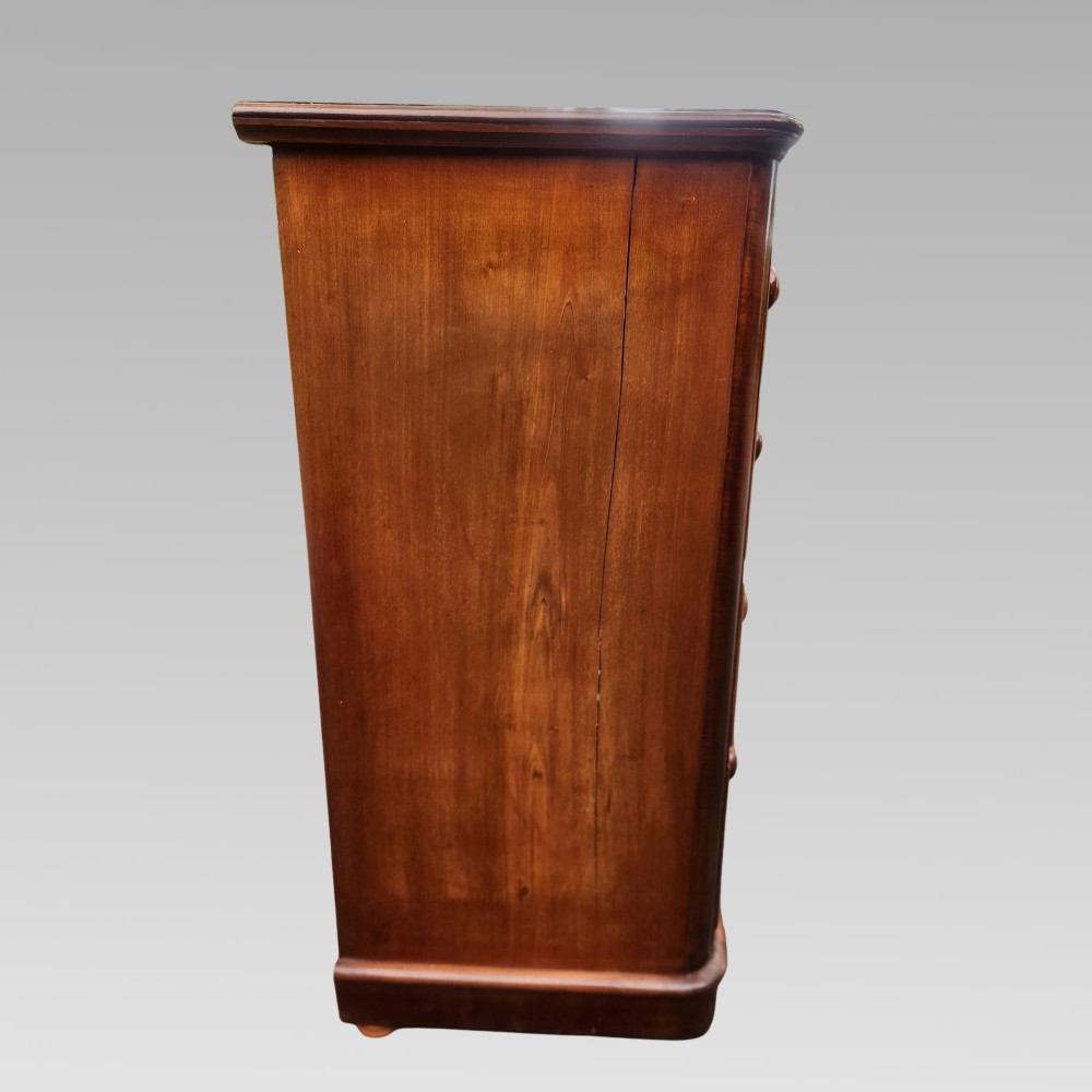 A Victorian mahogany chest of drawers featuring two short drawers above three full-width graduated drawers with turned wooden handles and a plinth base. View V