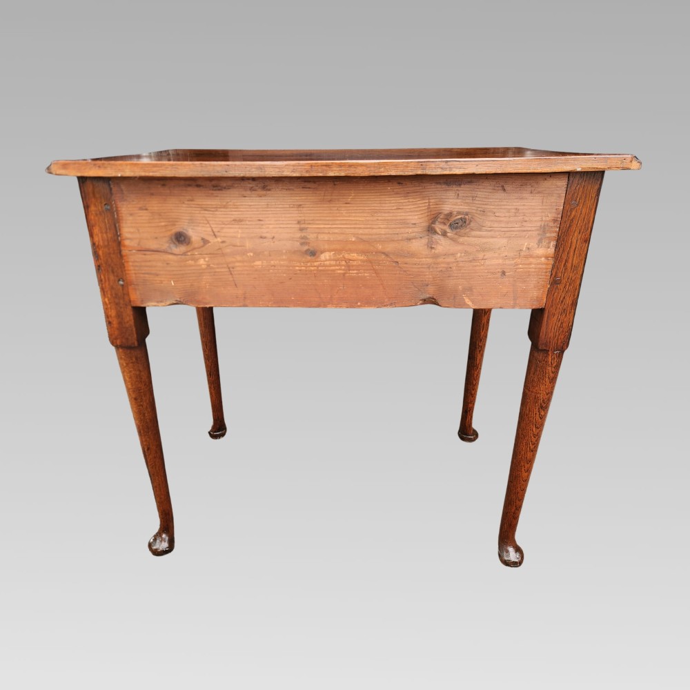 An antique Georgian oak lowboy side table featuring three drawers with brass handles, a shaped apron, and cabriole legs on pad feet. View VII