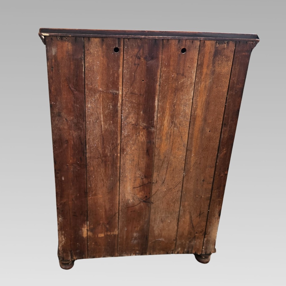 A dark brown Victorian English oak double-door storage cupboard with decorative black iron hinges and bun feet. View VI