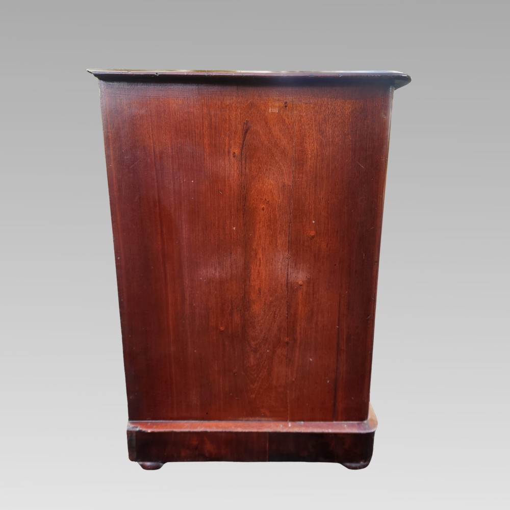 A Victorian mahogany chest of drawers featuring two short drawers over two long drawers with turned wooden handles, brass escutcheons, and a solid plinth base. View VII