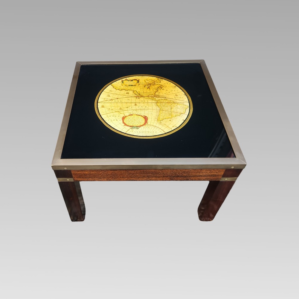A dark mahogany campaign style nest of three coffee tables featuring glass tops with inset world map illustrations and brass corner mounts. View IV