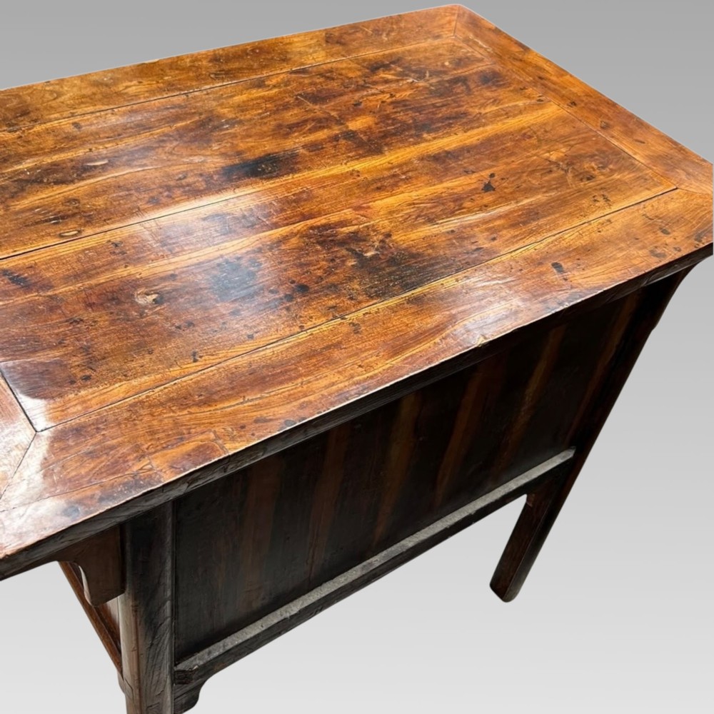 A warm brown Chinese elm console table featuring two upper drawers with metal drop handles and lower recessed timber panels. View IV