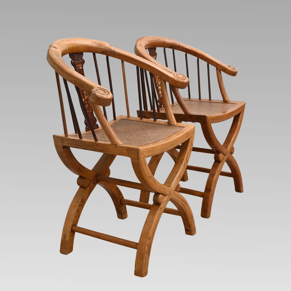 A pair of Chinese fruitwood horseshoe chairs featuring curved crest rails, vertical spindles, woven cane seats, cross-framed legs, and central carved splats with bone inlay. View III