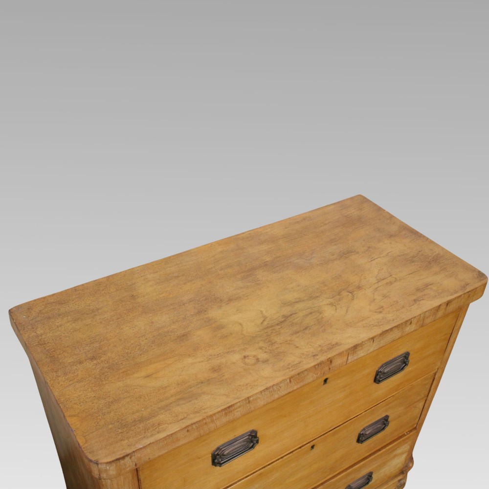 A Victorian light pine chest of drawers featuring three full-width drawers with brass recessed handle plates and turned bun feet. View II