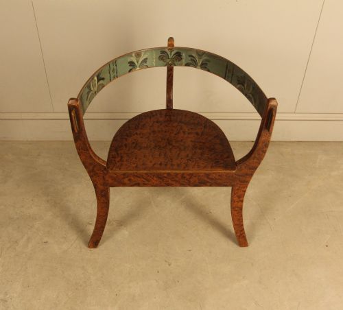 fig 2. An early 20th-century Norwegian wooden chair with a curved backrest decorated with hand-painted green floral motifs and a faux-grained finish.