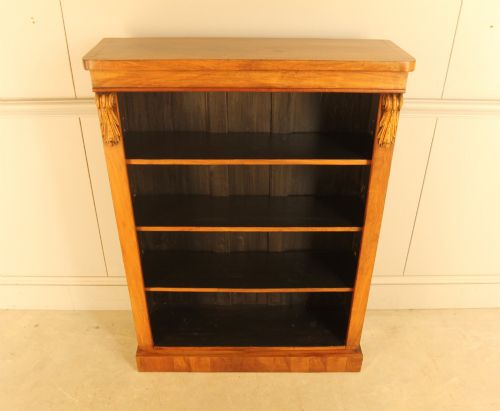 fig 2. A Victorian walnut open bookcase featuring four horizontal shelves, carved decorative corbels at the upper corners, and a dark painted backboard.