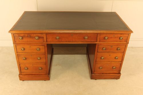 fig 1. A Victorian walnut pedestal desk featuring nine drawers with brass handles and a dark leather writing inset top.