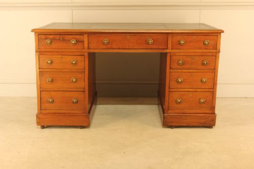 fig 2. A Victorian walnut pedestal desk featuring nine drawers with brass handles and a dark leather writing inset top.