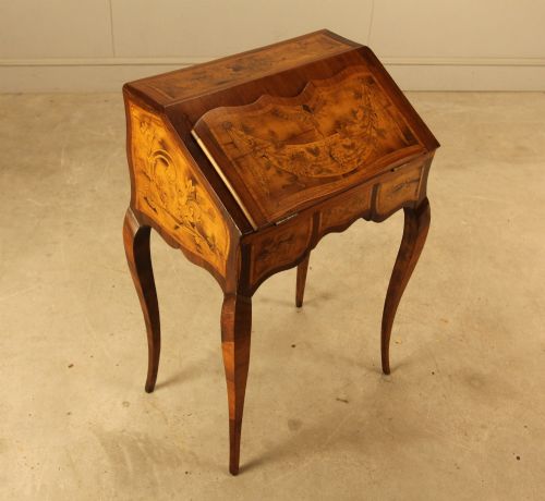 fig 3. A 19th-century Italian walnut writing bureau featuring floral marquetry inlay, a slanted fall front, and slender cabriole legs.