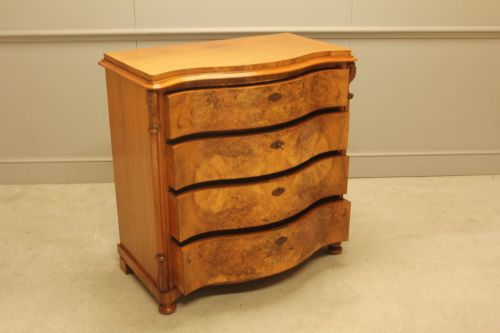 fig 3. A 19th-century Swedish burr walnut chest of drawers featuring a serpentine front, four graduated drawers, brass escutcheons, and carved side pilasters.