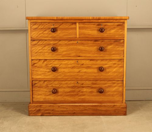 fig 1. A Victorian stained birch chest of drawers featuring a two short over three long drawer configuration with turned wooden knobs and a solid plinth base.