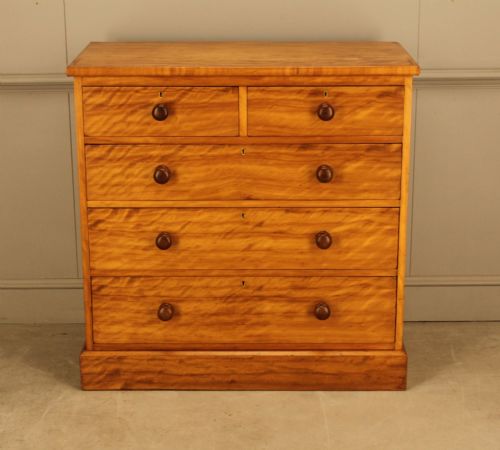 fig 3. A Victorian stained birch chest of drawers featuring a two short over three long drawer configuration with turned wooden knobs and a solid plinth base.