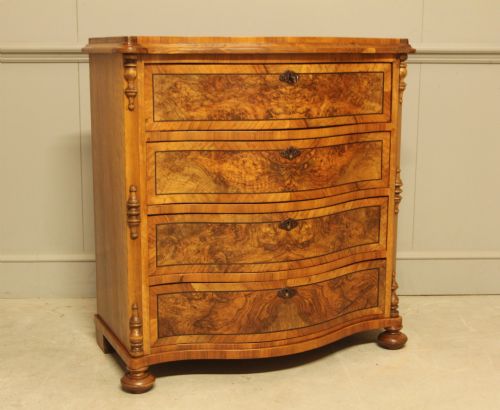 fig 1. A 19th-century Swedish burr walnut chest featuring four serpentine-front drawers, bookmatched veneers, turned side pilasters, and bun feet.