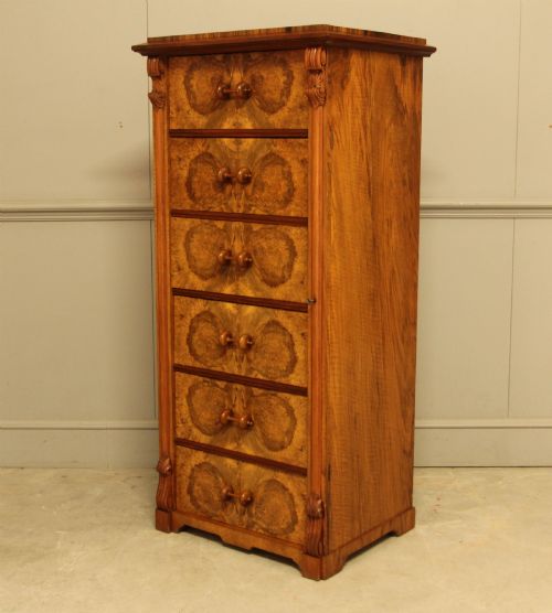 fig 2. A tall 19th-century Swedish Wellington chest featuring six book-matched burr walnut drawers with turned handles, flanked by carved pilasters.