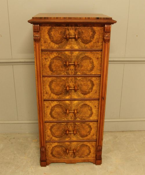 fig 3. A tall 19th-century Swedish Wellington chest featuring six book-matched burr walnut drawers with turned handles, flanked by carved pilasters.