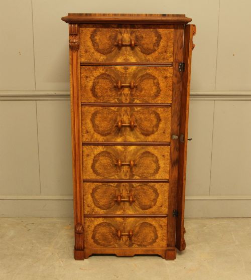 fig 5. A tall 19th-century Swedish Wellington chest featuring six book-matched burr walnut drawers with turned handles, flanked by carved pilasters.