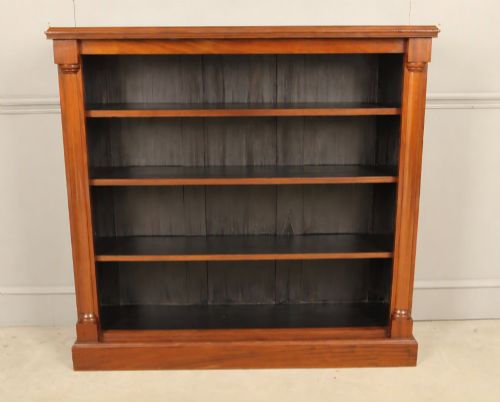 fig 1. A Victorian open mahogany bookcase featuring four shelves flanked by turned pilasters on a solid plinth base.