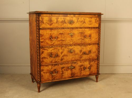 fig 1. A nineteenth-century Swedish chest of drawers crafted from highly figured flame birch veneer, featuring four full-width drawers with brass drop handles, brass escutcheons, and spiral-twisted side columns.