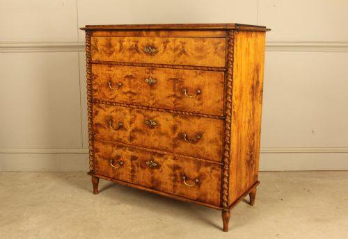fig 2. A nineteenth-century Swedish chest of drawers crafted from highly figured flame birch veneer, featuring four full-width drawers with brass drop handles, brass escutcheons, and spiral-twisted side columns.