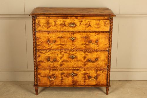 fig 3. A nineteenth-century Swedish chest of drawers crafted from highly figured flame birch veneer, featuring four full-width drawers with brass drop handles, brass escutcheons, and spiral-twisted side columns.