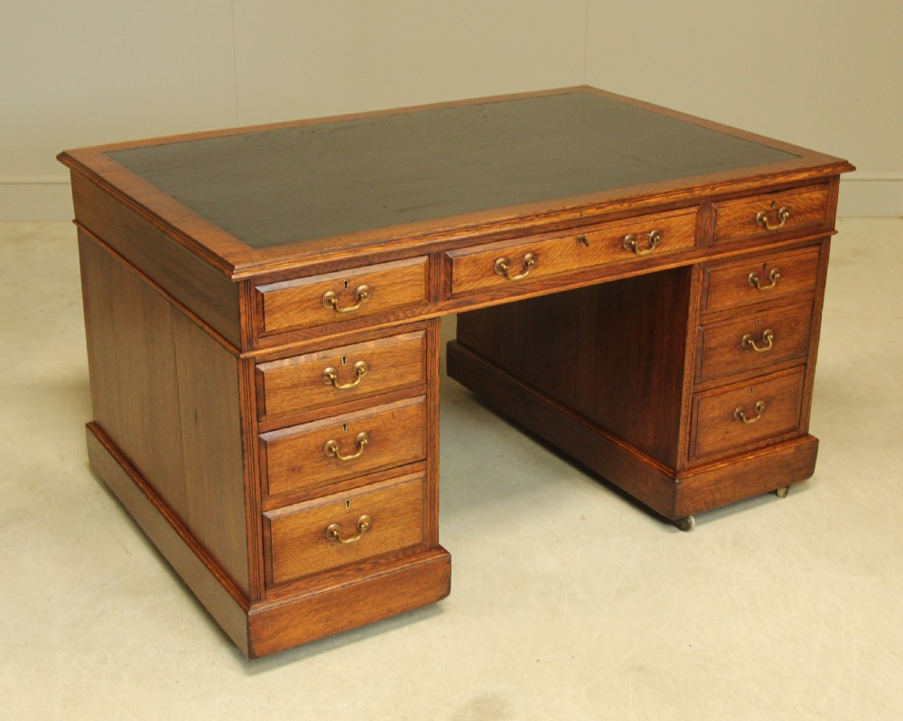An early 20th-century oak partner's desk 