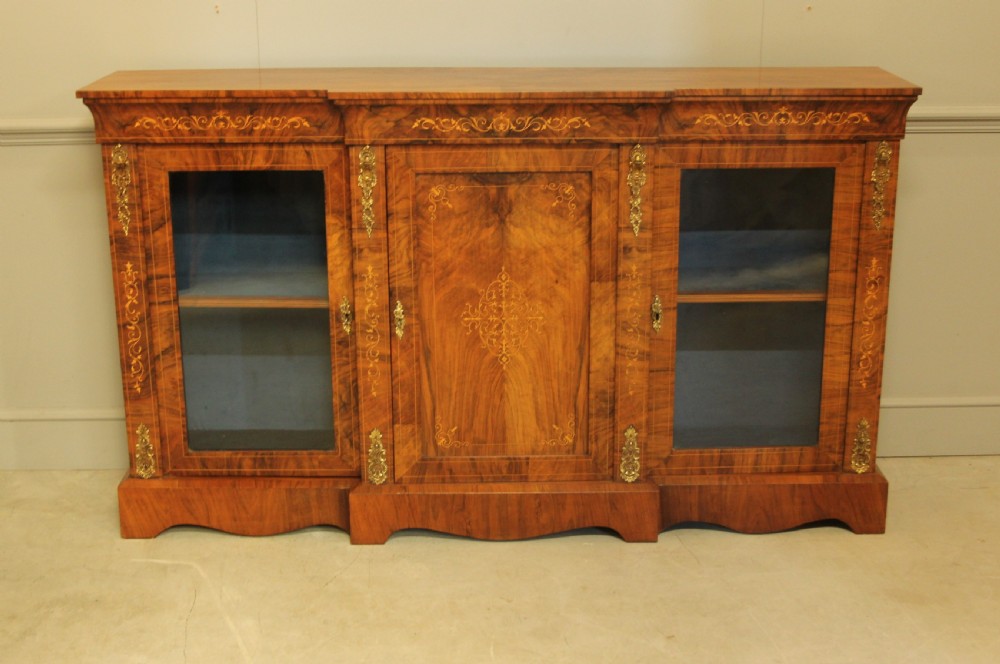 A Victorian low breakfront credenza crafted from burr walnut with marquetry inlay, gilt-brass mounts, a central panelled door, and two outer glazed doors. View III
