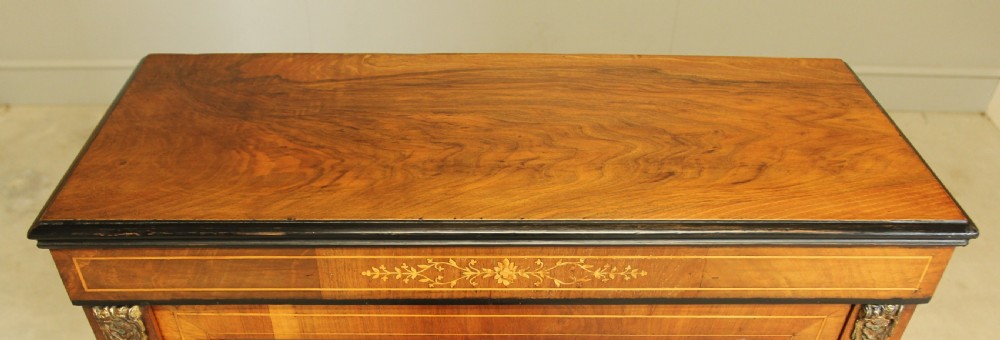 A Victorian walnut pier display cabinet featuring a single glazed door, floral marquetry inlay, decorative brass mounts, and turned feet. View IX