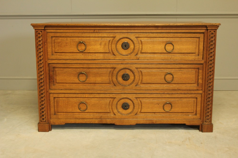 A 19TH CENTURY FRENCH OAK CHEST OF DRAWERS. View II