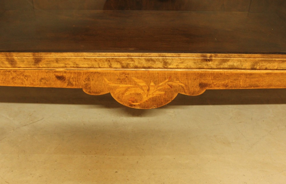 An early 20th-century Swedish low bookcase in figured satin birch veneer featuring three glazed front doors. View X